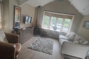 a living room with two couches and a tv at The Mill House in Tintagel