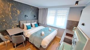a bedroom with a bed and a table and a chair at Willa Marion in Karpacz