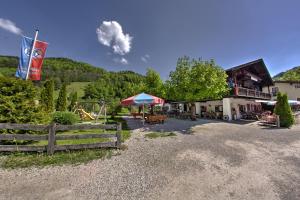 a resort with a playground and a building with a fence at Wirtshaus und Pension Hocheck in Ramsau
