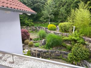 a garden with a stone wall and plants at Diane Appartement in Scheer
