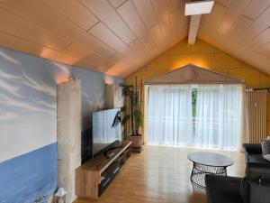 a living room with a couch and a tv at Diane Appartement in Scheer
