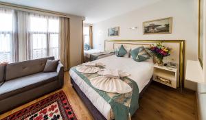 伊斯坦布尔苏丹楼酒店的一间酒店房间，里面有一张床和一张沙发