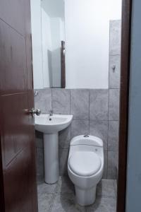 a bathroom with a toilet and a sink at Hostal Paracas I in Ica
