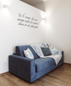 a blue couch in a room with a quote on the wall at A'mare in Giovinazzo