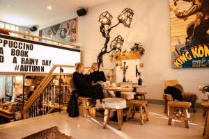 due donne sedute in una stanza piena di mobili di King Kong Hostel a Rotterdam