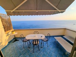 a table and chairs on a balcony with the ocean at Il Limoneto in Furore