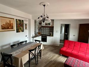 a living room with a table and a red couch at Numero 33 in Cori