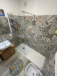 a bathroom with a sink and a glass shower at Lady Marzamemi in Marzamemi