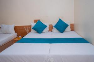 a bed with blue and white pillows in a room at SAIGAL Guest House in Mumbai