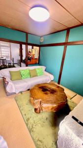 a room with two beds with a log on the floor at Rumakita Otaru in Otaru