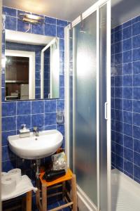 a blue tiled bathroom with a sink and a shower at Colosseo Ohana Suite in Rome +21 photos