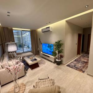 a living room with a couch and a tv at شقة مودرين بجاكوزي واطلالة على البحر in Al Khobar +14 photos