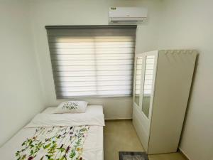 a small room with a bed and a window at Casa Kappa alibutsweg 15 in Paramaribo