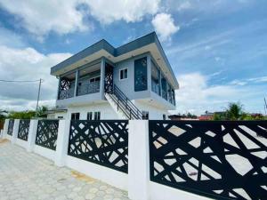 a white house with a black and white fence at Casa Kappa alibutsweg 15 in Paramaribo