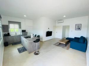 a living room with a blue couch and a kitchen at Casa Kappa alibutsweg 15 in Paramaribo