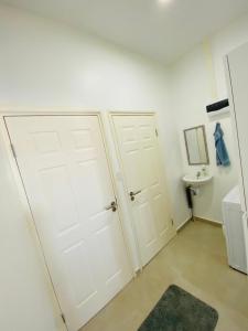 a bathroom with two white doors and a sink at Casa Kappa alibutsweg 15 in Paramaribo +27 photos