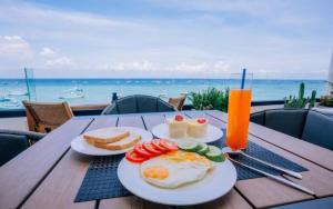 a table with two plates of eggs and bread and a drink at New Moon Hotel Phu Quy in Cu Lao Thu