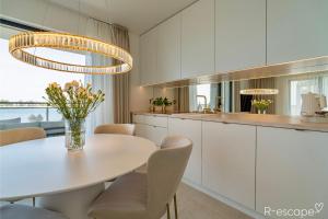 eine Küche mit weißem Tisch und Stühlen und ein Esszimmer in der Unterkunft R-escape Apartamenty Ostróda in Ostróda