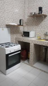 a kitchen with a stove and a counter top at Résidence Mamanta St louis in Saint-Louis +9 photos