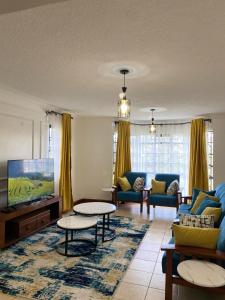 a living room with a couch and a tv at Goodness in Nairobi