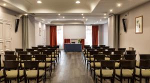 a room with rows of chairs and a podium at Sina Maria Luigia in Parma