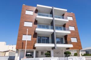 a tall brick building with white balconies at City Hall Suites in Limassol