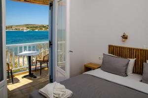 een slaapkamer met een bed en een balkon met uitzicht op de oceaan bij Hotel Livadia in Parikia