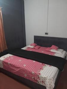 - une chambre dotée d'un lit avec des draps roses et blancs dans l'établissement Wayanad Wildlife Sactuary Bamboo Groves, à Jāmb