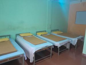 - un groupe de trois lits dans une chambre dans l'établissement Wayanad Wildlife Sactuary Bamboo Groves, à Jāmb