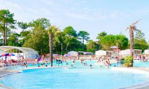 a group of people in a pool at a resort at Au Ferret plage,piscines à 2 pas en famille by Vayny in Lège-Cap-Ferret