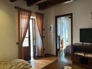 Un dormitorio con una cama y un televisor y puertas. en Casa Maria, en Cannobio