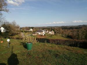 a shadow of a person in a field with houses at Charmante petite maison proche de Meymac in Meymac
