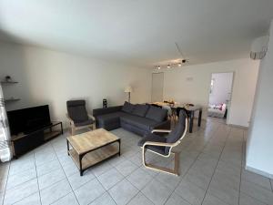 Lyo pavillon في فالراس بلاج: غرفة معيشة بها أريكة وطاولة