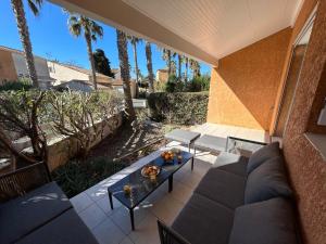 Lyo pavillon في فالراس بلاج: فناء مع أريكة وطاولة والنخيل