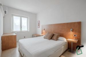 a bedroom with a large white bed and a window at Hotiday Apartments Portoferraio in Portoferraio