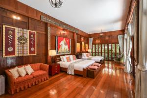 a bedroom with two beds and a couch at Luxury Hannah Villas in Chiang Mai