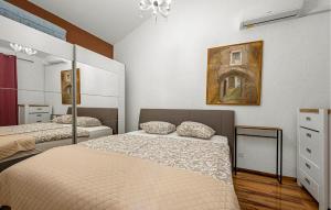 a bedroom with two beds and a painting on the wall at 2 Bedroom Nice Home In Jezera in Jezera