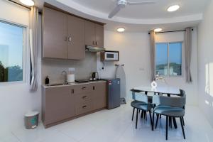 a kitchen with wooden cabinets and a table and chairs at Pearls Apartments in Ukulhas