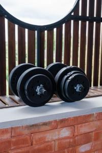 two black dumbbells sitting on a bench at Baliris Canggu Villa by Betterplace in Tumbak Bayuh +116 photos