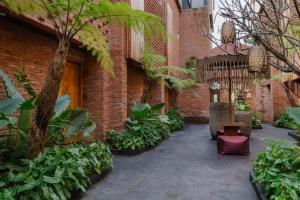 a courtyard of a building with a bench and plants at Baliris Canggu Villa by Betterplace in Tumbak Bayuh
