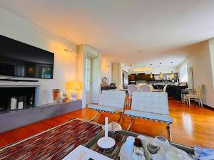 un soggiorno con sedie bianche e camino di Exclusive Villa with Private Swimming Pool a Nicola