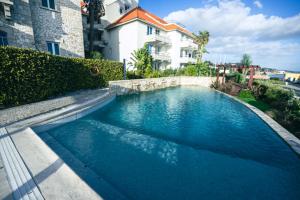a swimming pool in front of a building at Hotel Solar Palmeiras in Paço de Arcos