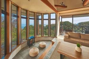 a living room with a couch and a fireplace at プライベートリゾート熱川 in Higashiizu