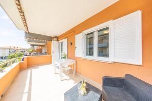 a balcony with an orange wall and a table at “la casetta al mare” in Anzio +7 photos