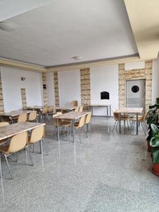 a room with tables and chairs and a fireplace at Motel Mesterul Manole in Curtea de Argeş