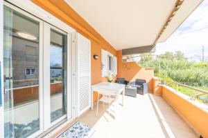a balcony with a white desk and large windows at “la casetta al mare” in Anzio