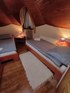 a bedroom with a bed and a table with two lamps at Vozi Rooms in Méhkerék