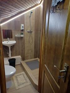 a bathroom with a shower and a toilet and a sink at Vozi Rooms in Méhkerék
