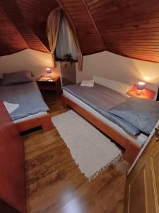 two beds in a room with wood floors and two lamps at Vozi Rooms in Méhkerék +14 photos