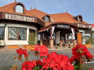 a restaurant with red flowers in front of a building at Vozi Rooms in Méhkerék